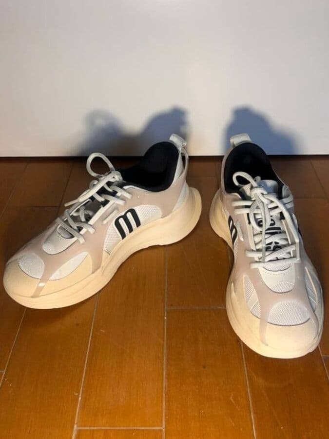 Phone photo of chunky sneakers, on a wooden floor